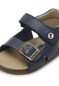 Marinblå läder sandal med två justerbara remmar, en med en mässingsspänne. Suede-liknande innersula och texturerad gummiyttersula.