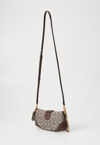 Small brown crossbody bag with signature monogram pattern, gold chain detail, leather trim, and adjustable leather strap on a white background.