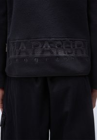 Pullover in fleece navy con un logo testurizzato a patch nell'orlo. Presenta un tessuto morbido e caldo, bordi arrotondati e una vestibilità rilassata.