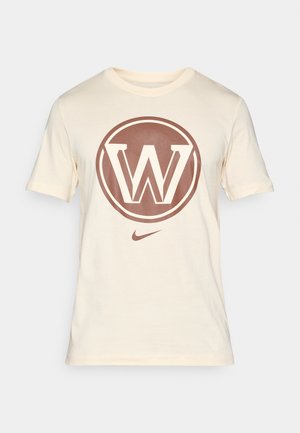 Ein off-white T-Shirt von Nike aus Baumwolle zeigt ein großes braunes, kreisförmiges Logo mit einem stilisierten "W" in der Mitte und einem kleinen Nike-Swoosh am unteren Rand.