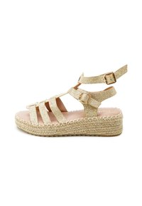 Glittery gold wedge sandals with multiple straps, adjustable buckle, and braided jute sole. Smooth interior and flat footbed.