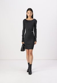 Musthave, sädelev must kehakleit pikka varrukatega ja paadikaelusega. Kanda koos musta käekotiga ja põlve pikkuste mustade saapatega.