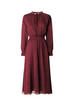 Vestido burdeos de manga larga con cintura fruncida, con un escote alto y lunares blancos, confeccionado en una tela ligera y fluida.