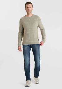 Maglione grigio chiaro in maglia con finitura testurizzata, scollo rotondo, polsini a costine, abbinato a jeans scuri e sneakers, vista a figura intera.
