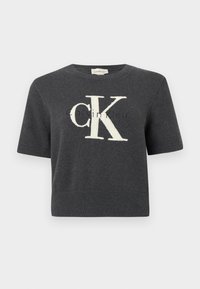 Pulover gri cu mâneci scurte, cu un logo mare "CK" alb pe partea din față, cu guler și tiv inferior rib. Textură moale tricotată.