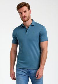 Kurzärmliges Poloshirt in blauer Farbe. Weicher, glatter Stoff mit einer Knopfleiste mit drei Knöpfen und einem kleinen Logo auf der Brust. Slim-Fit-Design.
