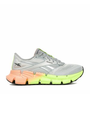Szary but do biegania Reebok z siateczkową cholewką, neonowo-żółtą i brzoskwiniową segmentowaną podeszwą oraz czarną spodem, widziany od strony zewnętrznej.