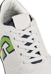 Weiße Sneaker mit einem strukturierten Obermaterial aus Leder, buntem gesticktem Logo in Grün und Blau, navyblauen Akzenten und weißen Schnürsenkeln.