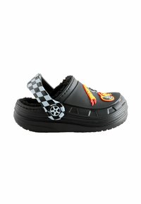 Black clogs with a fuzzy interior, checkerboard strap, and colorful flame and wheel designs on the front. Textured rubber sole for grip.
