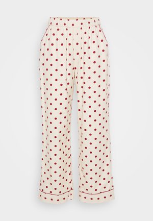 Pantaloni del pigiama color crema con pois rossi, dotati di una vita elasticizzata e tasche laterali. Il tessuto è morbido con una superficie liscia.