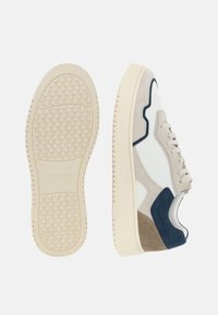 Tenis z belim usnjem, sivimi in mornarskimi zamaknimi akcenti, bež gumijastim podplatom, perforiranim dizajnom in teksturiranim profilom podplata.