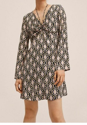 Zwart en crèmekleurige jurk met een patroon, lange mouwen, V-hals en knoopdetail op de borst. Kenmerkt bloemmotieven in tinten roze en beige.