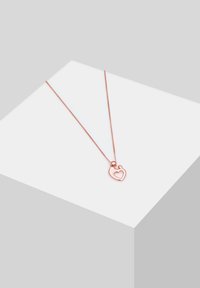 Rose gold halskæde med en tynd kæde, der har et hjerteformet vedhæng med et åbent center. Enkel design med en glat overflade.