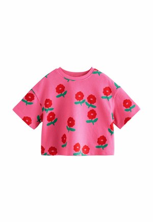 Rosa cropped t-shirt med korte ærmer, prydet med et blomsterdesign af røde blomster og grønne blade, lavet af blød stof med en tekstureret overflade.