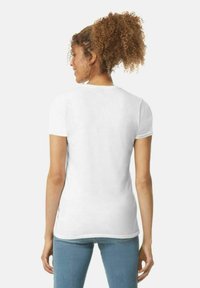 Hvid kortærmet T-shirt med en tætsiddende pasform, glat tekstur og rund halsudskæring, iført med blå jeans, set fra bagvenden.