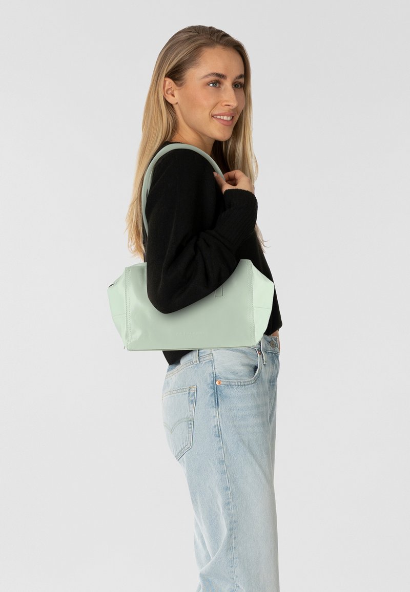 Licht mintgroene leren handtas met een gestructureerd ontwerp, korte dubbele handvatten en een fluweelachtige textuur. Voorzien van een ritsluiting en minimalistische styling.