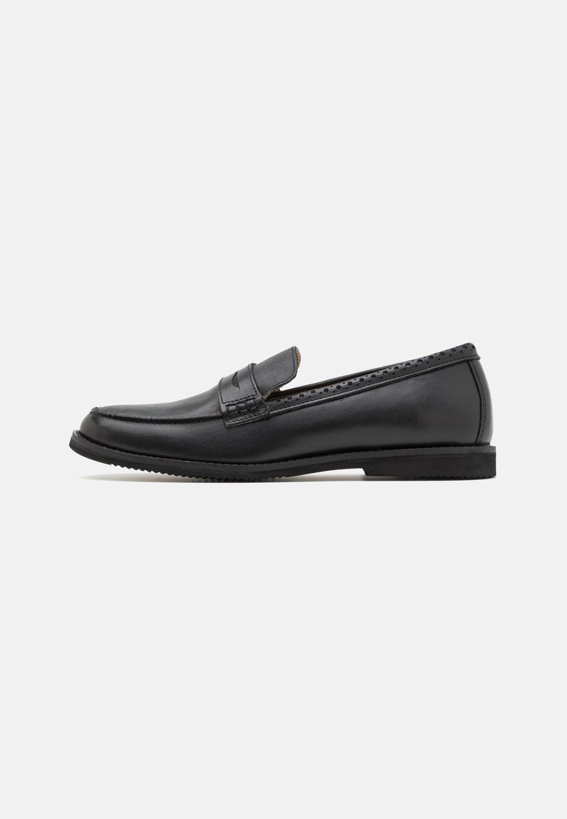 Mocassin noir en cuir pour homme avec un petit talon et des détails perforés le long du bord supérieur, vu de côté sur fond blanc.