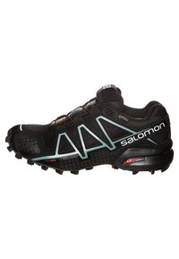 Zapatilla de running negra que presenta material de malla y sintético, una suela Contagrip y acentos en color aqua. Diseño con cordones y detalles estampados.