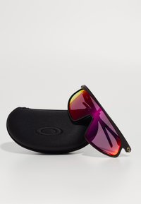 Ochelari de soare negri cu lentile mari, în degrade purpuriu și galben, cu un design elegant și o husă de protecție neagră.