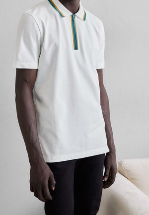 Witte polo met korte mouwen, voorzien van een ritskraag met blauwe en gele strepen. Gemaakt van een soepele katoenmix.