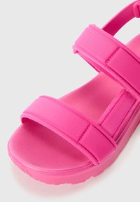 Felle roze sandalen met dubbele stoffen banden en een gestructureerde voetbed. Voorzien van een lichte zool en een gladde rubberen onderkant voor grip.
