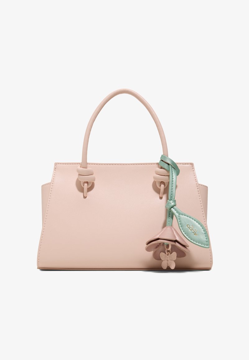 Sac à main rose blush avec poignée arrondie, détails noués, et un charm fleur bleu sarcelle avec un papillon suspendu sur le côté droit.