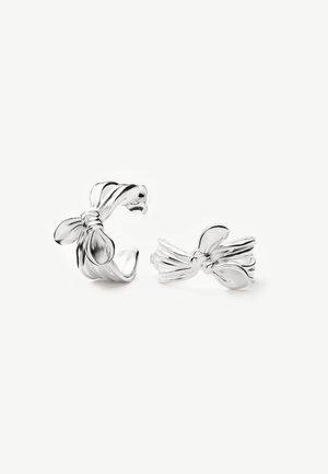 Pendientes plateados en forma de nudo retorcido con un acabado liso y pulido, uno mostrado de perfil y otro de frente sobre un fondo blanco.