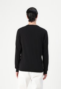 Schwarz, langärmeliges T-Shirt aus weichem Material, mit klassischem Rundhalsausschnitt und lockerer Passform. Keine sichtbaren Muster oder Verzierungen.