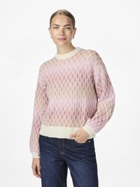 Strikkegenser i lys rosa og krem med et mesh-mønster, ribbestrikkede mansjetter og nederkant. Brukt sammen med mørke denimjeans.