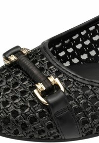 Chaussure plate tissée noire dotée d'un dessus texturé, d'une bordure en cuir et d'un détail décoratif en boucle accentué d'or. Intérieur doublé de tissu à motifs.