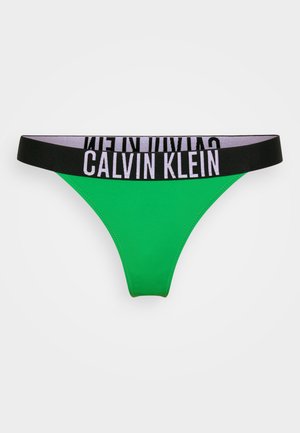 Žalias džinsinis trikampis kelnaitės, su juodu ir pilku elastingu juosmeniu, ant kurio išryškinta „CALVIN KLEIN“ logo ryškiomis raidėmis. Lygus paviršius, minimalistinis dizainas.