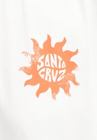 Πορτοκαλί ήλιος με στυλιζαρισμένες ακτίνες και το κείμενο "SANTA CRUZ" σε έντονα, κυματιστά γράμματα στο εσωτερικό, σε λευκό φόντο.