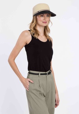 Chapeau en paille beige avec un bord noir, porté avec un débardeur noir et un pantalon taille haute en kaki. La ceinture est noire avec une texture tissée.