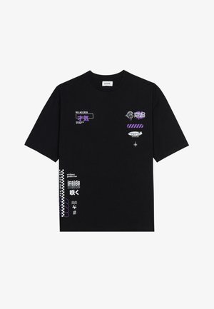 Fekete pamut póló, különböző lila és fehér grafikákkal, beleértve szövegeket és szimbólumokat. A kialakítás lazán illeszkedő, rövid ujjú.