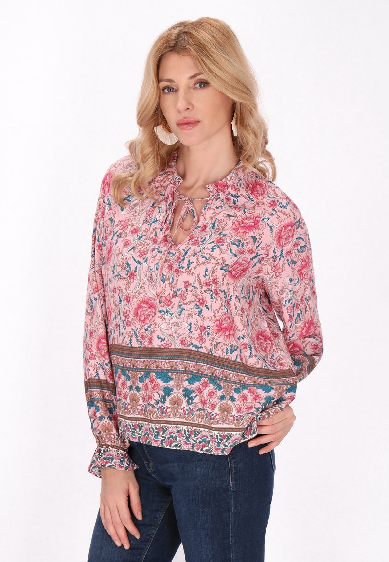 Bluză imprimată floral în nuanțe de roz și albastru, cu guler tip keyhole, mâneci lungi cu manșete volănoase și o margine cu model.