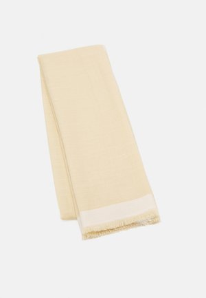 Écharpe en tissu plié de couleur crème avec une texture tissée subtile et des bords frangés à une extrémité.