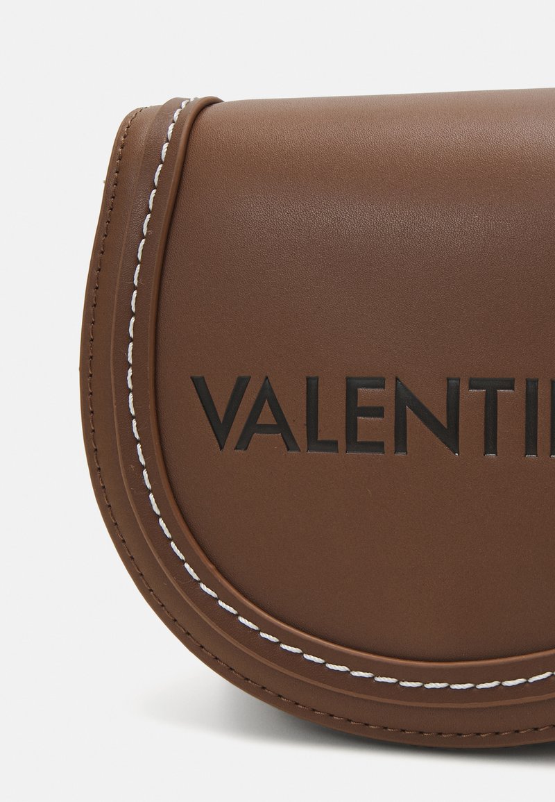 Braune Lederhandtasche mit runder Form, geprägtem "VALENTINI"-Logo und weißen Nähten. Glatte Textur, minimalistischer Stil.