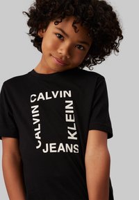 Calvin Klein Jeans MAXI HERO FLOCK LOGO - Apdrukāts T-krekls - black
