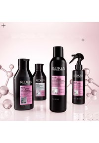 De Redken Acidic Color Gloss-collectie bestaat uit vier zwarte flessen met roze etiketten, met verschillende haarverzorgingsproducten en pH-informatie.