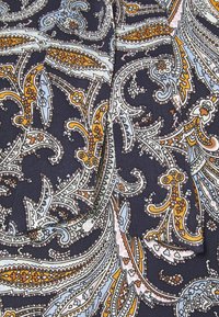 Tissu marine avec un motif paisley complexe en orange, blanc et bleu clair. Présente une texture lisse et un travail de ligne détaillé.