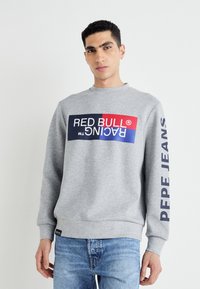 Sivi dukserica s okruglim izrezom, s velikim višebojnom logotipom sprijeda i natpisom "PEPE JEANS" otisnutim na rukavu. Udoban kroj.