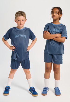 Marinblå sportkläder med vertikala ränder, bestående av kortärmade tröjor och shorts, tillsammans med blå skor och vita strumpor.