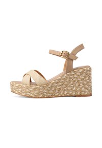 Sandalo con zeppa caratterizzato da una base in fibra naturale intrecciata, cinturini sintetici beige, design a incrocio e una fibbia alla caviglia regolabile.