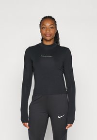 Musttee pika varrukatega spordisärg, kõrge kraega, millel on tumehall "PARIS" logo ja Nike'i tiib. Sile ja hästi istuv materjal.