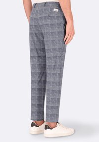 Pantaloni grigi a quadri realizzati in un tessuto testurizzato, con taglio dritto, passanti per cintura e due tasche posteriori. Abbinati a sneaker bianche.