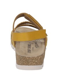 Geel leren sandaal met een kurken zool, verstelbare band en een zachte voetbed. Heeft een gestructureerde bovenkant en een stevig ontwerp.
