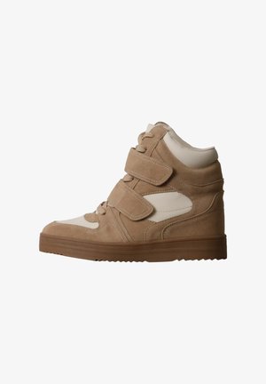 Basket montante beige avec deux bandes Velcro, lacets à l'avant et semelle épaisse marron, vue de côté sur fond blanc.