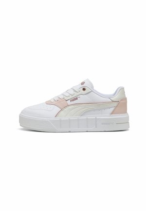 Baskets basses Puma blanches et rose clair avec lacets à l’avant, semelle épaisse, logo latéral et détails cousus sur fond uni.