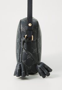 Borsa in pelle blu scuro con una texture a motivi e una forma rotonda. Presenta una tracolla e due decorazioni che somigliano a mani.