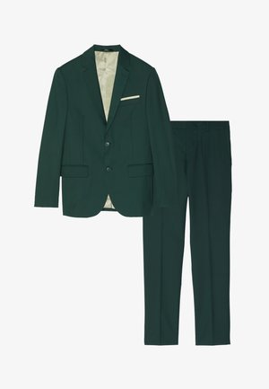 Abito verde scuro con giacca aderente a due bottoni e tasche a patta, abbinato a pantaloni su misura coordinati, entrambi con una texture liscia.